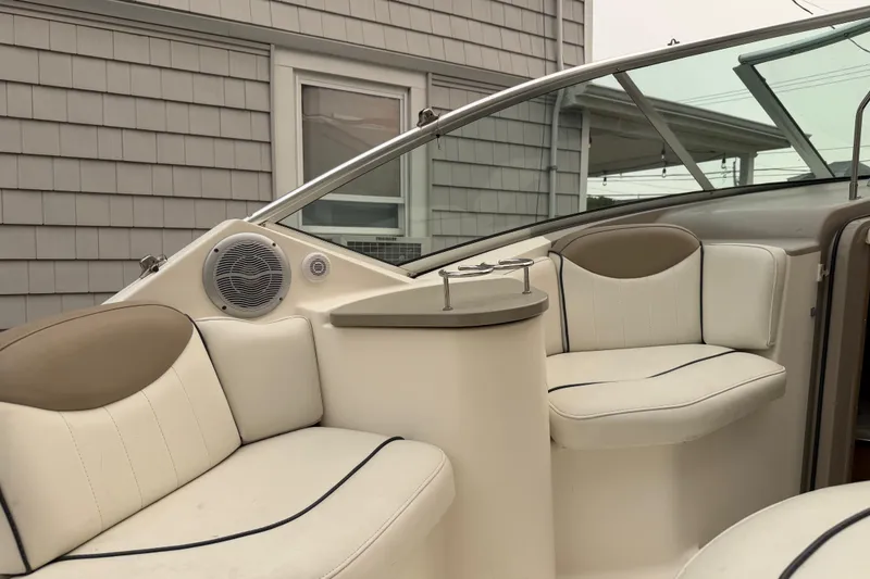Slide: The Image of 2006 Sea Ray 240 Sundancer boat interior with white seating and speaker system. - 6