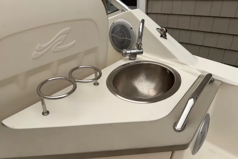 Slide: The Image of 2006 Sea Ray 240 Sundancer boat sink area with cup holders and speaker. - 8
