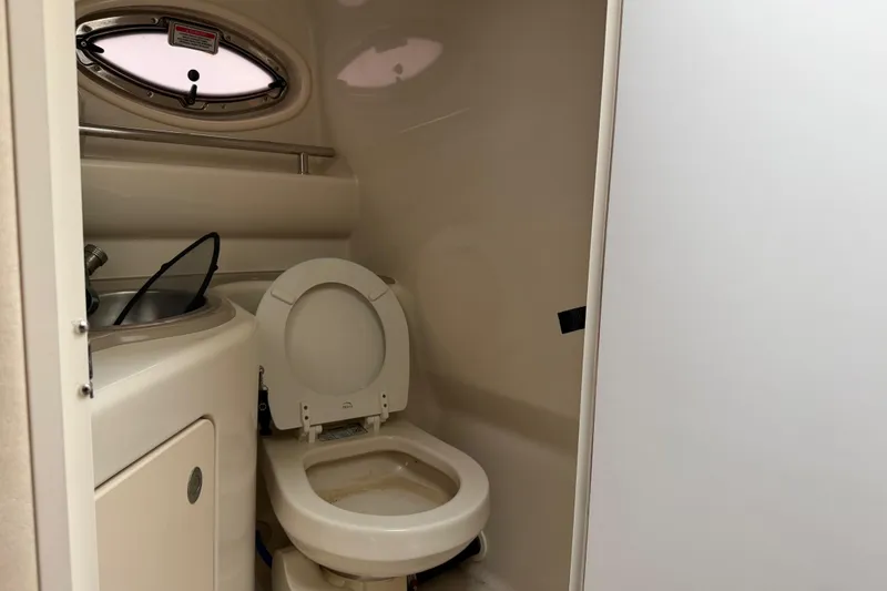 Slide: The Image of 2006 Sea Ray 240 Sundancer boat bathroom with toilet and sink. - 15