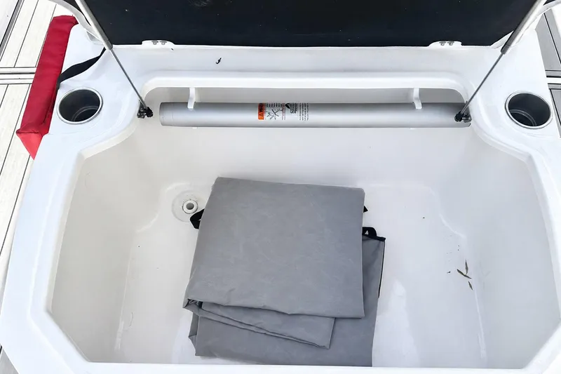 Slide: The Image of Open storage compartment on a 2002 Sea Fox 228 Commander boat with folded gray cover. - 39
