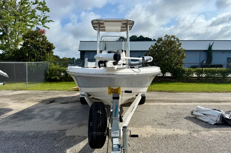 Slide: The Image of 2023 Robalo 206 Cayman boat on trailer, parked outdoors under cloudy sky. - 2