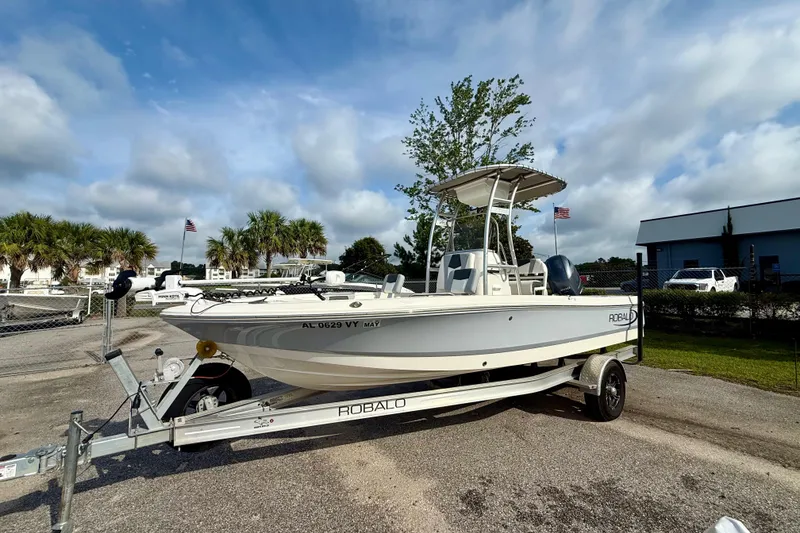Slide: The Image of 2023 Robalo 206 Cayman boat on trailer, parked outdoors under a cloudy sky. - 3