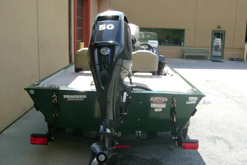 Slide: The Image of 2026 Tracker Bass Tracker Classic Limited boat with 50 HP motor, parked outdoors. - 4