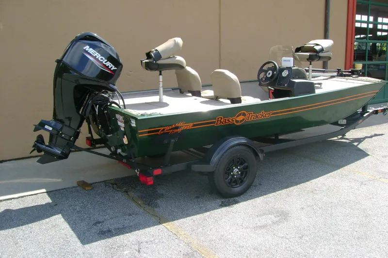 Slide: The Image of 2026 Tracker Bass Tracker Classic Limited boat with Mercury engine, parked on a trailer. - 2