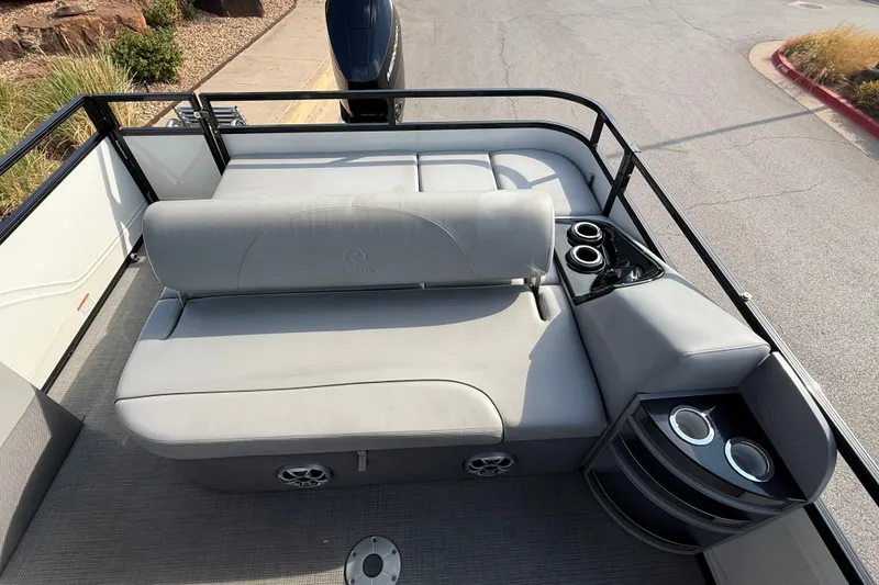 Slide: The Image of 2024 Regency 250 DL3 pontoon boat interior with plush seating and cup holders. - 8
