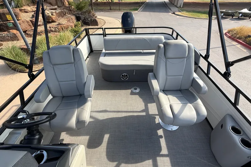 Slide: The Image of 2024 Regency 250 DL3 pontoon boat interior with plush seating and steering console. - 7