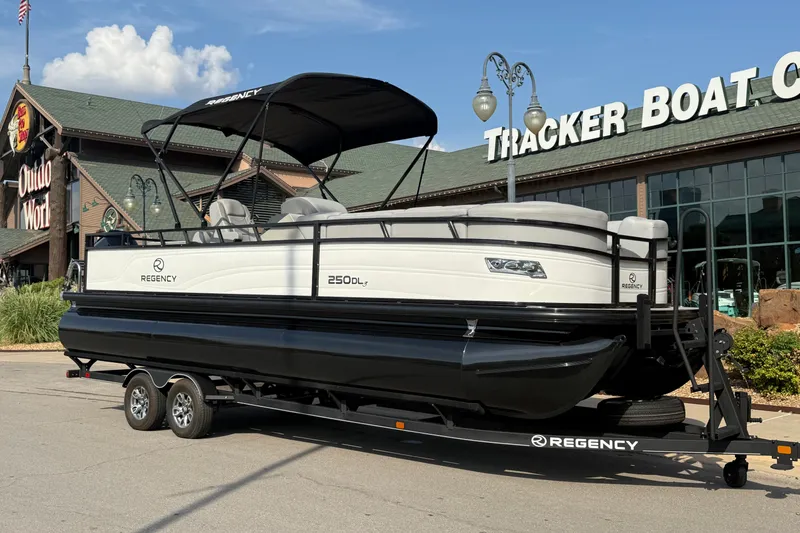 Slide: The Image of 2024 Regency 250 DL3 pontoon boat on trailer outside Tracker Boat Center. - 14