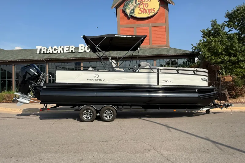 Slide: The Image of 2024 Regency 250 DL3 pontoon boat parked outside Tracker Boats store. - 11