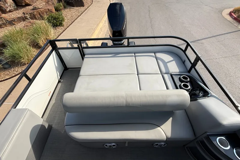 Slide: The Image of 2024 Regency 250 DL3 pontoon boat with spacious seating and cup holders, docked near a walkway. - 9
