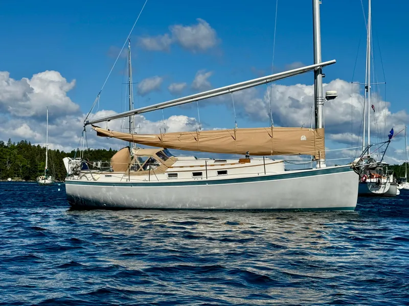 Slide: The Image of 1989 Nonsuch 30 Ultra sailboat on calm water under blue sky. - 10