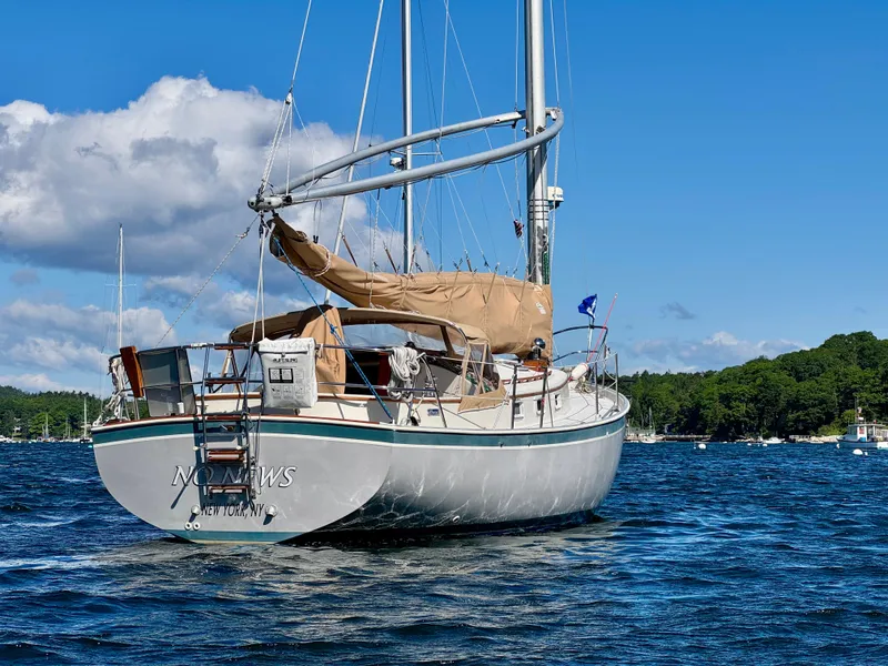 Slide: The Image of 1989 Nonsuch 30 Ultra sailboat on a sunny day, anchored in a scenic bay. - 2