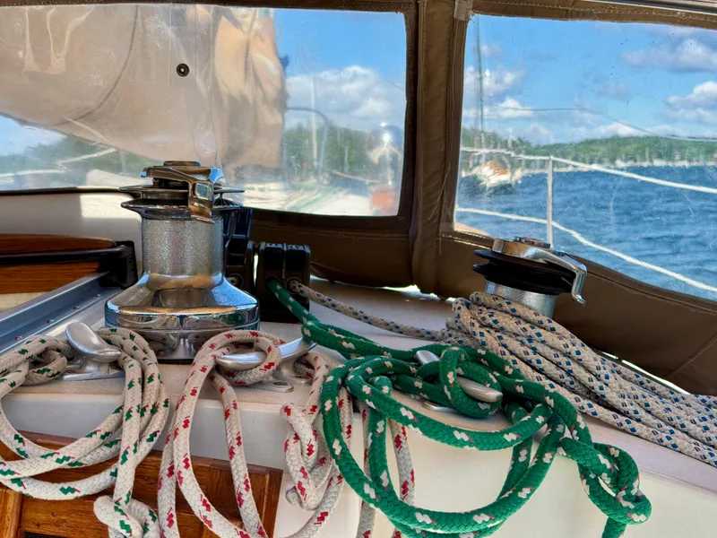 Slide: The Image of Sailing ropes and winches on a 1989 Nonsuch 30 Ultra boat, with a scenic water view. - 24