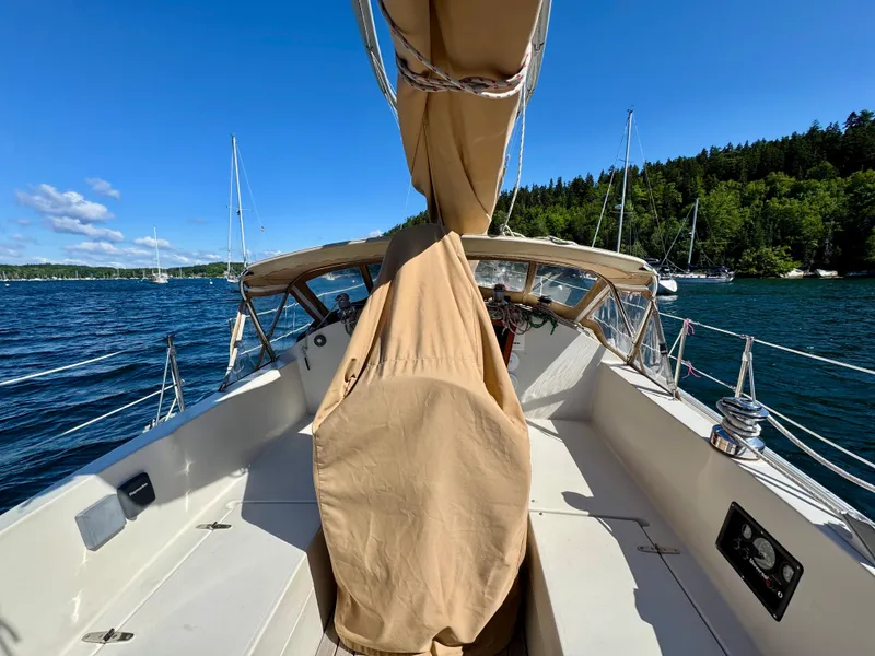 Slide: The Image of 1989 Nonsuch 30 Ultra sailboat on a sunny day, surrounded by water and trees. - 25