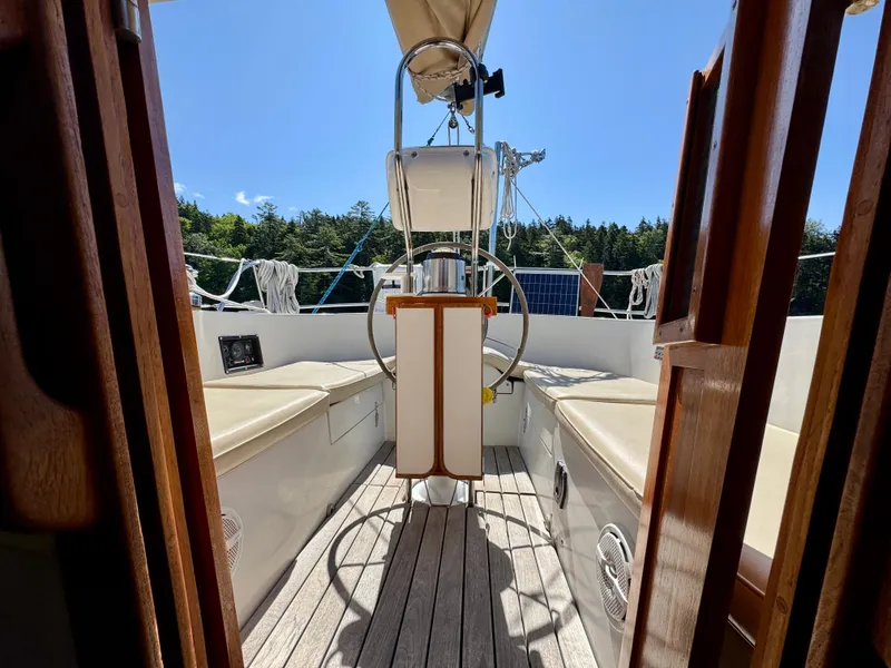 Slide: The Image of 1989 Nonsuch 30 Ultra sailboat cockpit with wooden accents and steering wheel. - 30