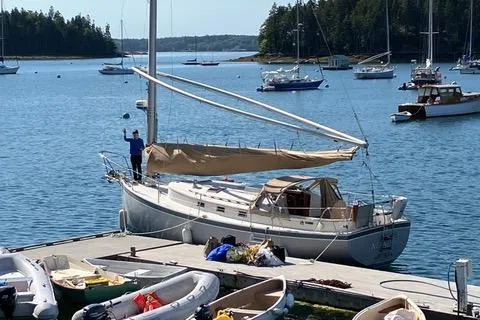 Slide: The Image of Sailboat Nonsuch 30 Ultra, 1989 model, docked at a scenic marina with surrounding boats. - 4