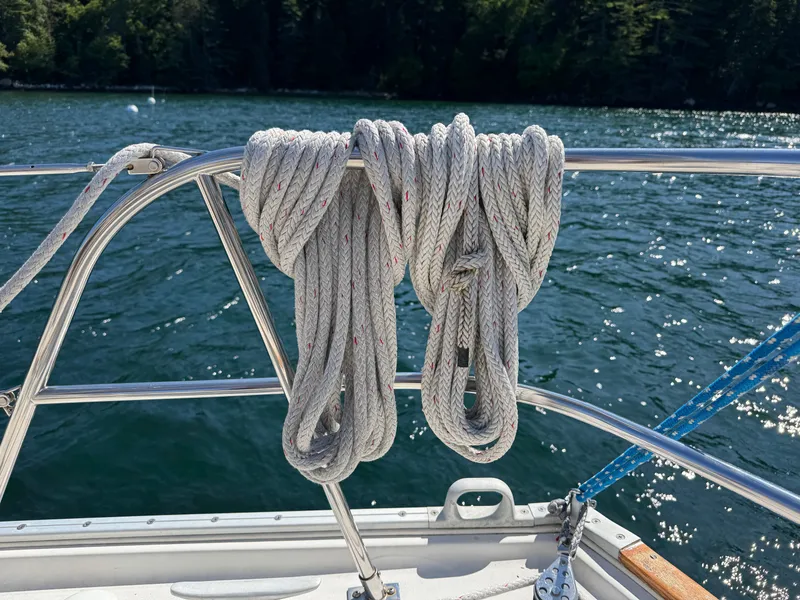 Slide: The Image of Coiled rope on 1989 Nonsuch 30 Ultra sailboat railing, with water background. - 40