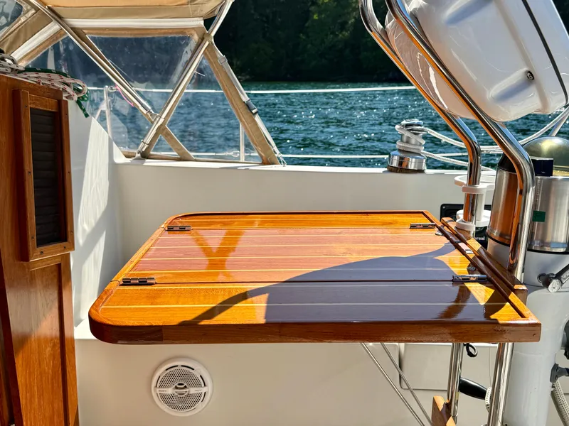 Slide: The Image of Polished wooden table on 1989 Nonsuch 30 Ultra sailboat, with scenic water view. - 42