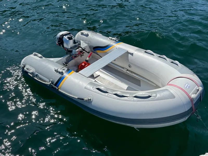 Slide: The Image of Inflatable dinghy with outboard motor floating on water, sunny day. - 43