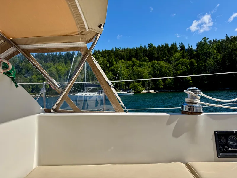 Slide: The Image of View from a 1989 Nonsuch 30 Ultra sailboat, overlooking serene waters and lush green forest. - 46