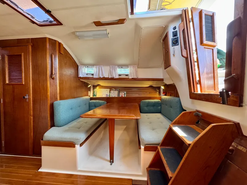 Slide: The Image of Interior of 1989 Nonsuch 30 Ultra sailboat with wooden furnishings and blue cushioned seating. - 49