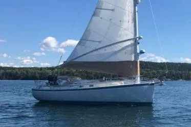 Slide: The Image of 1989 Nonsuch 30 Ultra sailboat on calm water under a clear blue sky. - 9