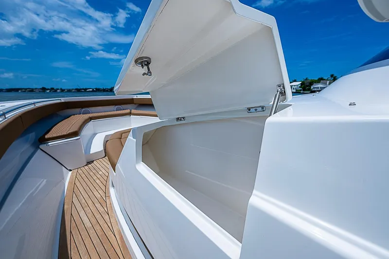 Slide: The Image of Open storage compartment on 2021 Gulf Crosser 52 boat deck, with seating and blue sky background. - 12