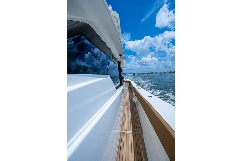 Slide: The Image of Side view of 2021 Gulf Crosser 52 yacht cruising on a sunny day. - 13