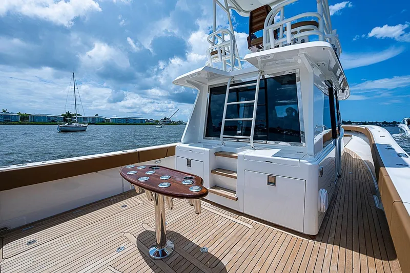 Slide: The Image of Luxurious 2021 Gulf Crosser 52 yacht with spacious deck and elegant seating, docked by the water. - 24