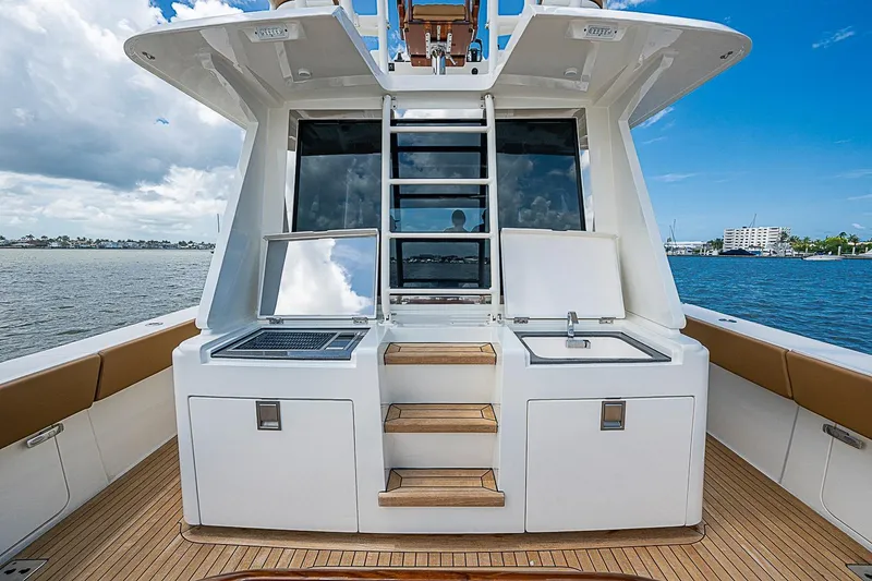 Slide: The Image of Luxury Gulf Crosser 52 yacht deck with outdoor kitchen, 2021 model, featuring grill and sink. - 27