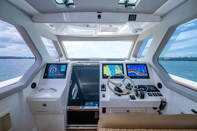 Slide: The Image of Luxurious 2021 Gulf Crosser 52 yacht cockpit with advanced navigation displays and steering wheel. - 38