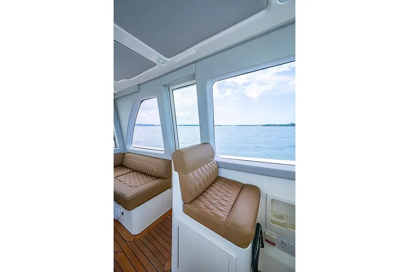 Slide: The Image of Interior view of 2021 Gulf Crosser 52 yacht with brown leather seating and ocean view. - 48