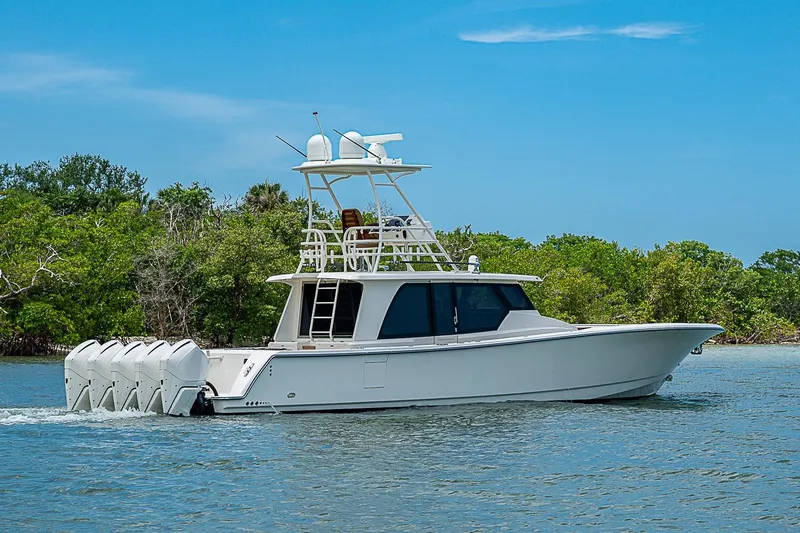 Slide: The Image of 2021 Gulf Crosser 52 boat cruising on a serene waterway with lush greenery. - 54
