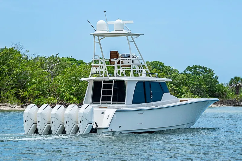 Slide: The Image of 2021 Gulf Crosser 52 boat with multiple engines cruising on a serene waterway. - 55