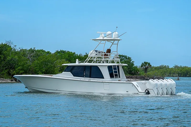 Slide: The Image of 2021 Gulf Crosser 52 yacht cruising on a serene waterway with lush greenery. - 60
