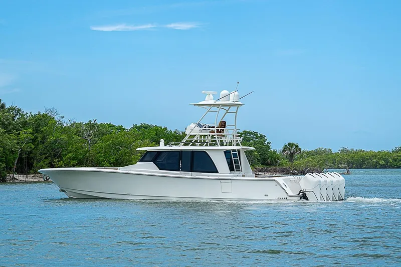 Slide: The Image of 2021 Gulf Crosser 52 yacht cruising on a serene waterway with lush greenery. - 61