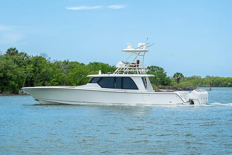 Slide: The Image of 2021 Gulf Crosser 52 yacht cruising on a serene waterway with lush greenery. - 62