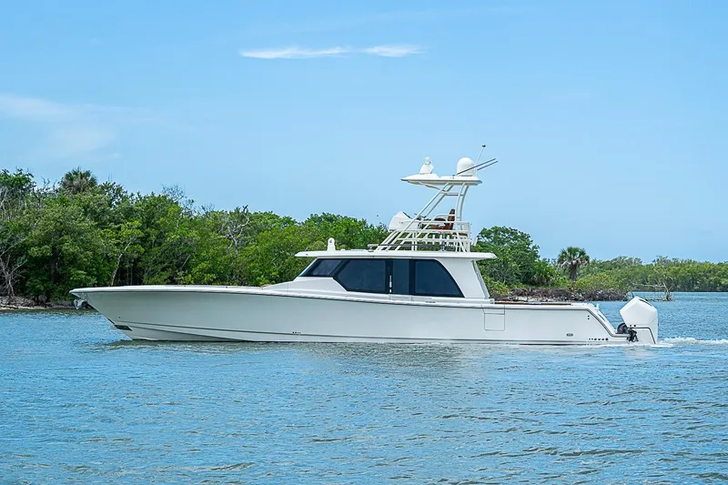 Slide: The Image of 2021 Gulf Crosser 52 yacht cruising on a serene waterway with lush greenery. - 63