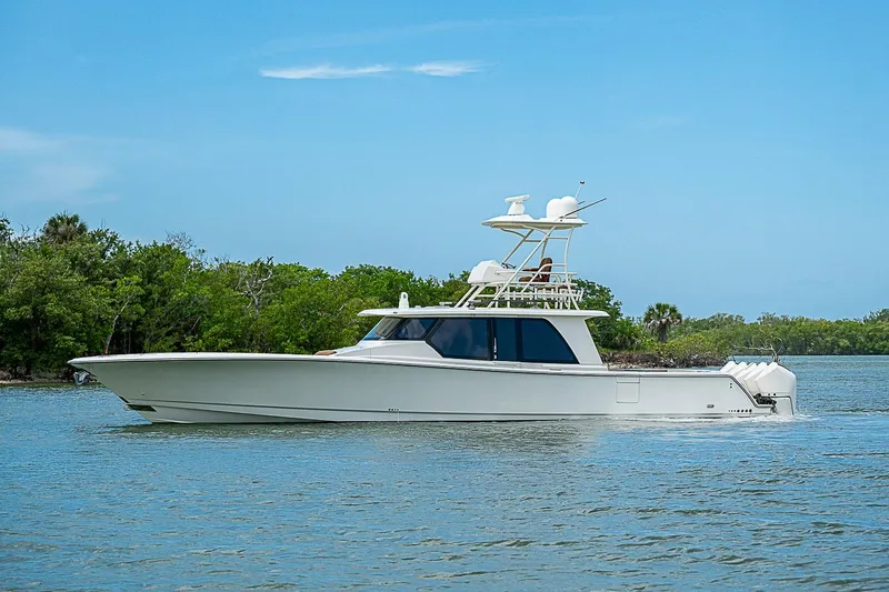 Slide: The Image of 2021 Gulf Crosser 52 yacht cruising on a serene waterway with lush greenery. - 64