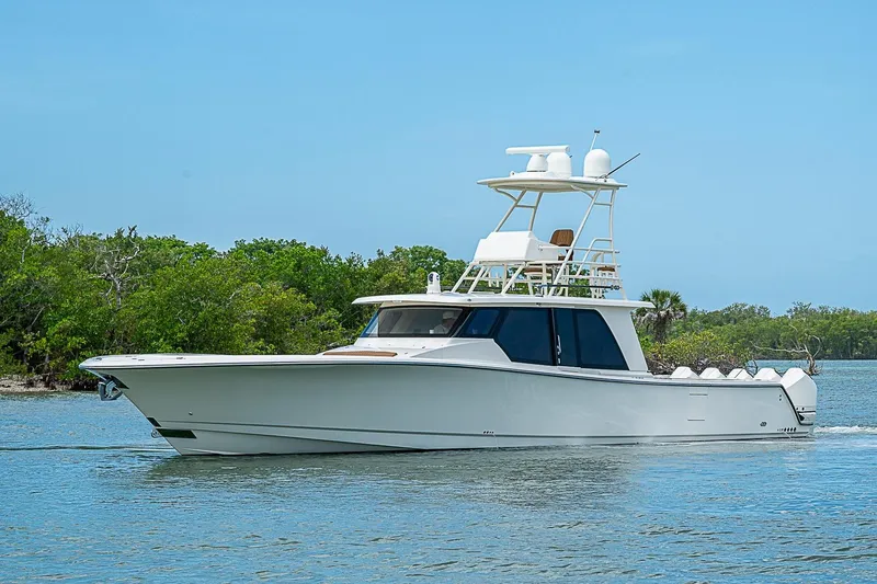 Slide: The Image of 2021 Gulf Crosser 52 yacht cruising on a serene waterway with lush greenery. - 66