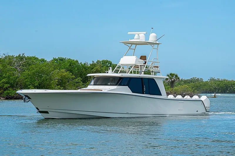 Slide: The Image of 2021 Gulf Crosser 52 yacht cruising on a serene waterway with lush greenery. - 67