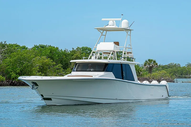Slide: The Image of 2021 Gulf Crosser 52 yacht cruising on a serene waterway with lush greenery. - 68