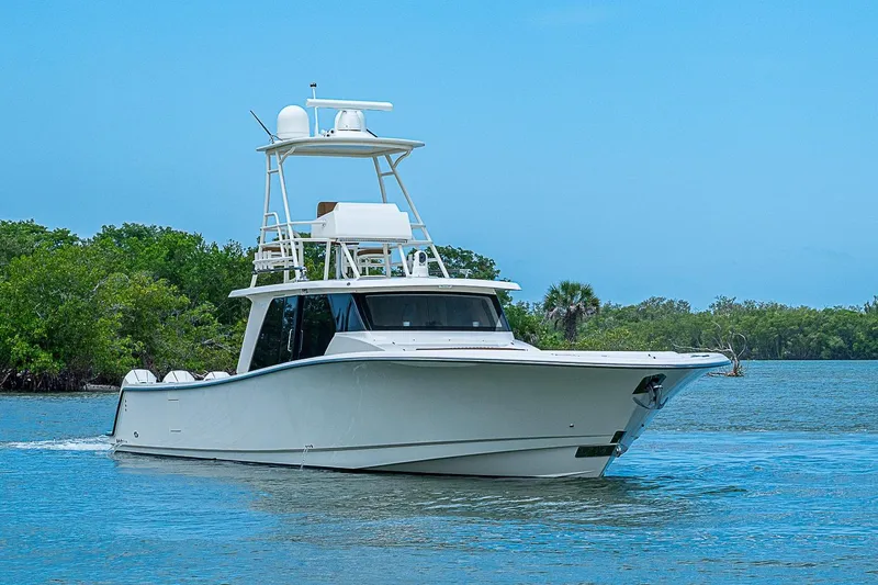 Slide: The Image of 2021 Gulf Crosser 52 yacht cruising on a serene waterway with lush greenery. - 70