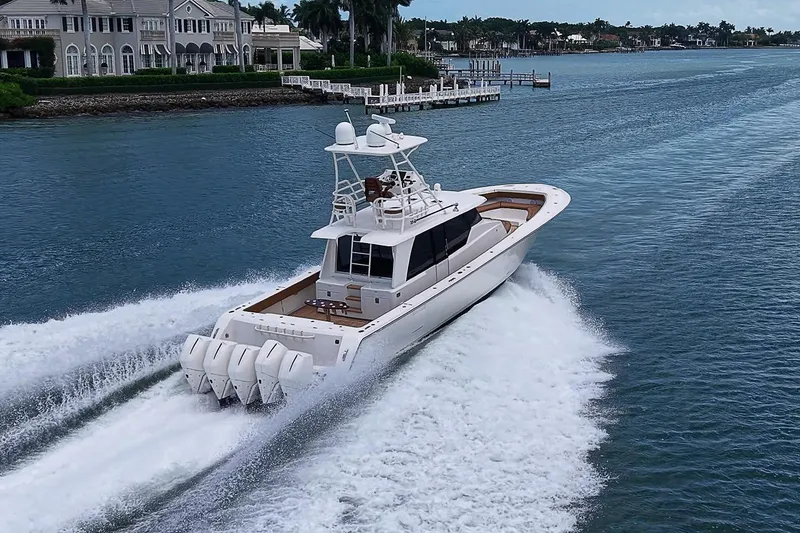 Slide: The Image of 2021 Gulf Crosser 52 yacht cruising on a scenic waterway near luxury homes. - 92