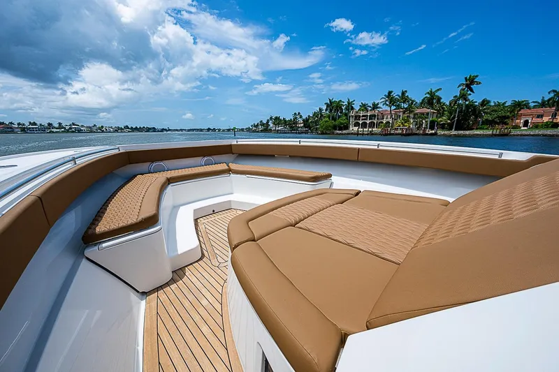 Slide: The Image of Luxurious 2021 Gulf Crosser 52 yacht deck with brown seating and scenic waterfront view. - 99