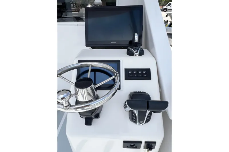 Slide: The Image of 1973 Bertram 31 Flybridge Cruiser helm with steering wheel and navigation controls. - 32