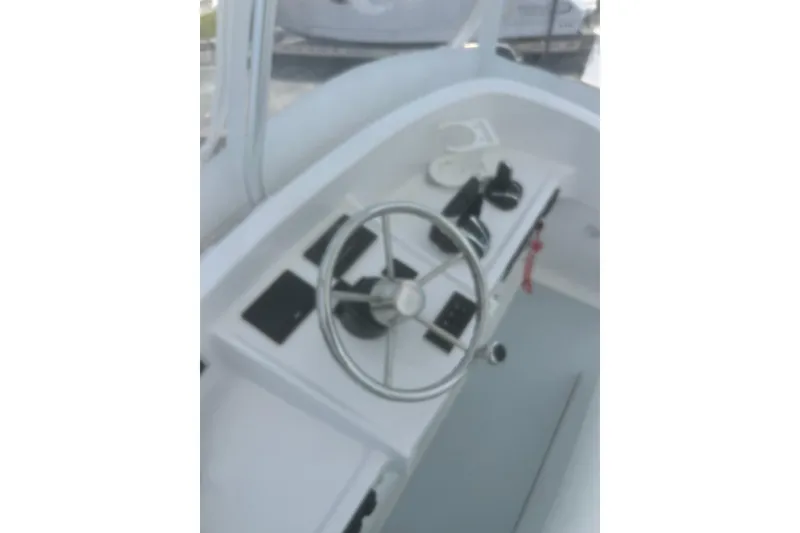 Slide: The Image of 1973 Bertram 31 Flybridge Cruiser helm with steering wheel and controls. - 21