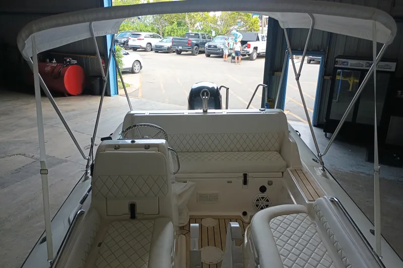 Slide: The Image of 2014 AB Inflatables Nautilus 17 DLX boat interior with seating and canopy in a garage. - 17