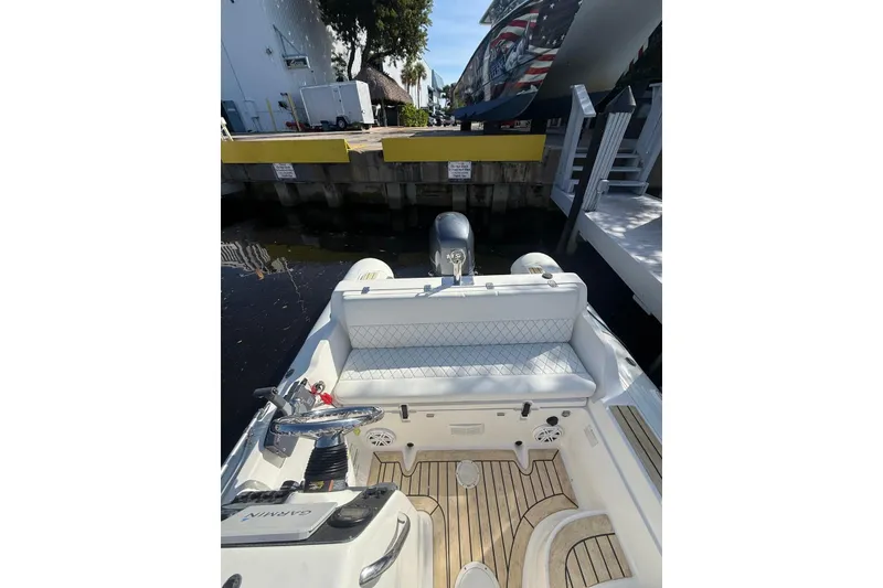 Slide: The Image of 2014 AB Inflatables Nautilus 17 DLX boat interior with seating and steering, docked by the water. - 22