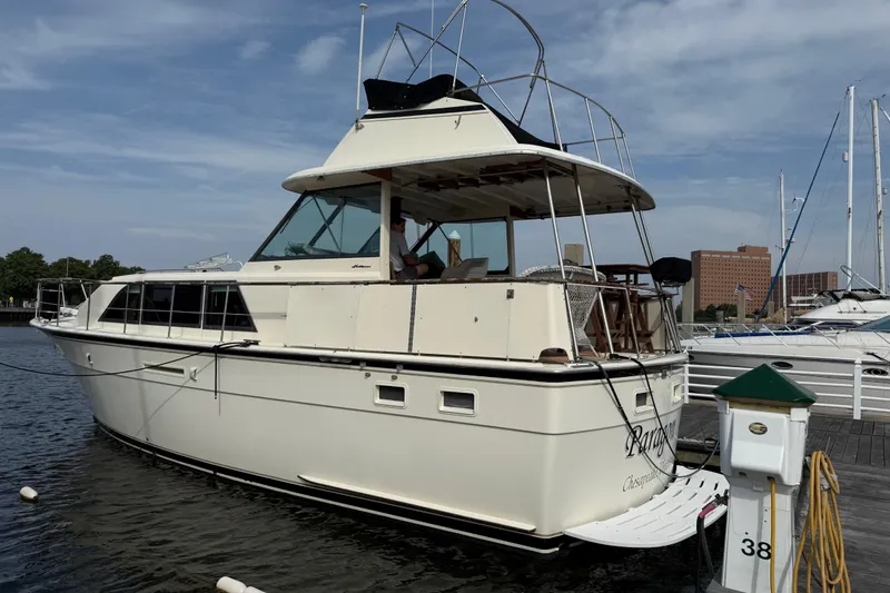 The Image of 1981 Hatteras 43 Motor Yacht docked at marina, clear sky background. - 0