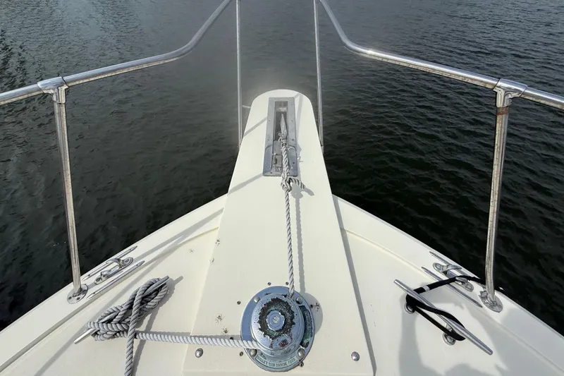 Slide: The Image of Bow view of 1981 Hatteras 43 Motor Yacht with anchor and railing over water. - 18